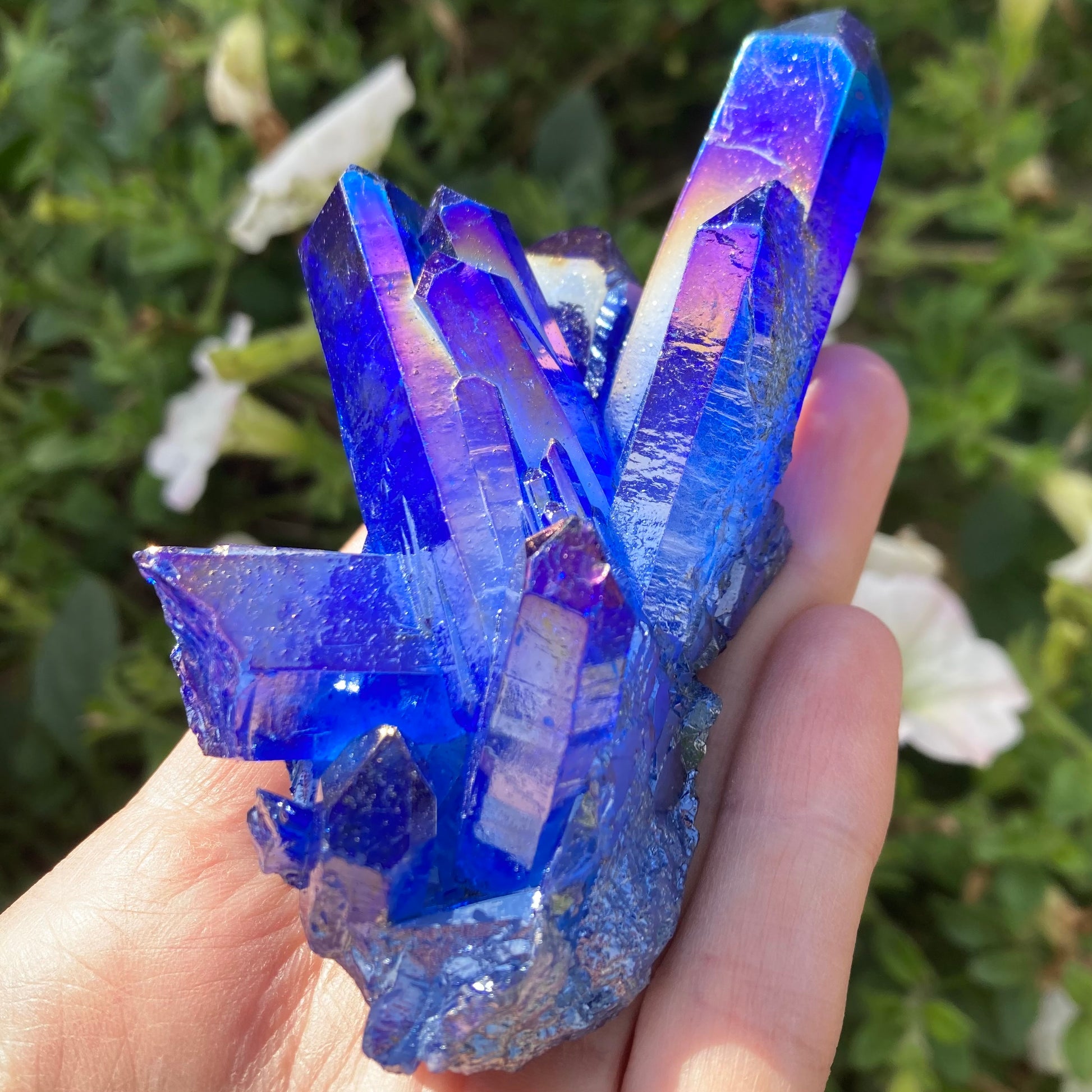 Cobalt blue aura quartz crystal in hand