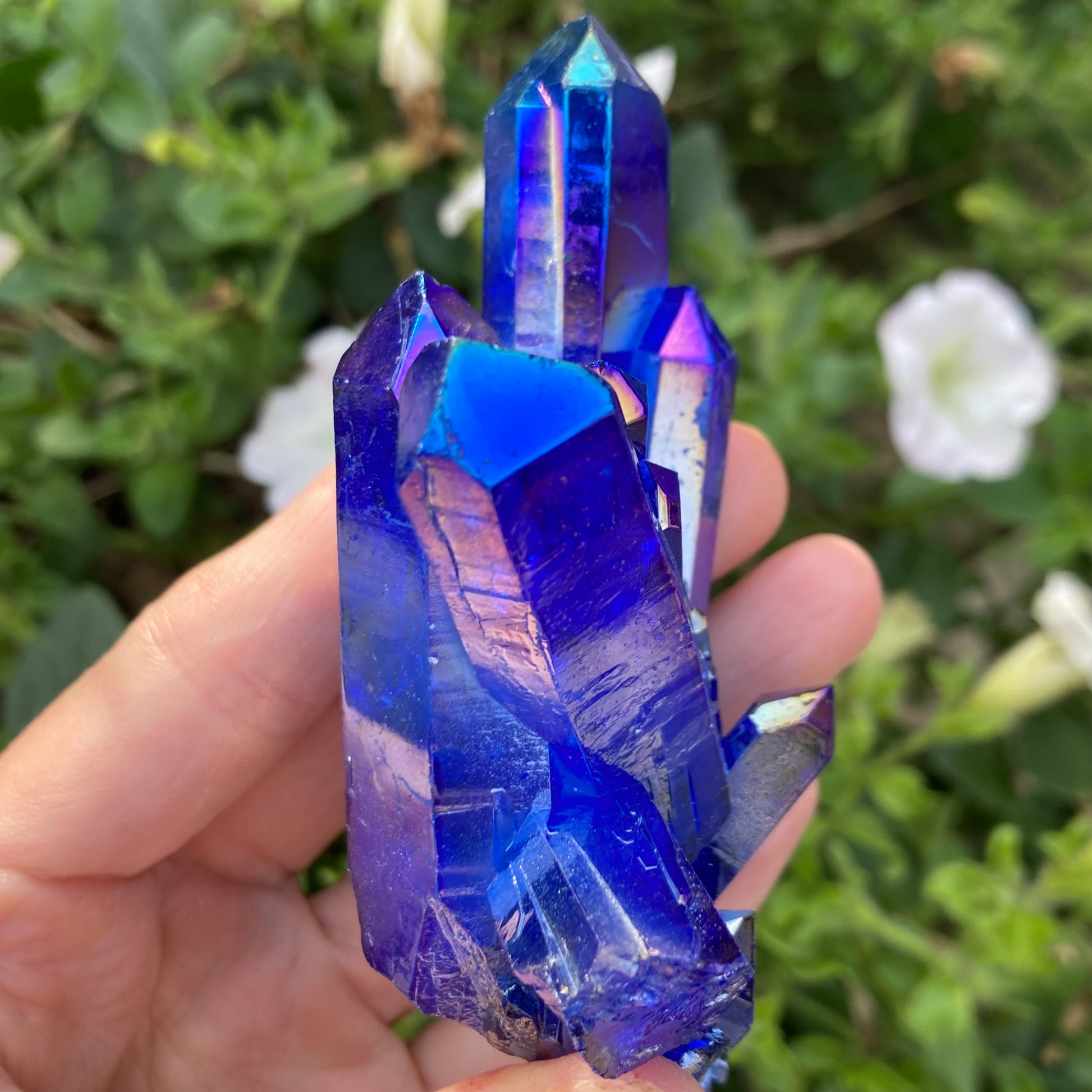 Rainbow colours on surface of blue aura quartz crystal