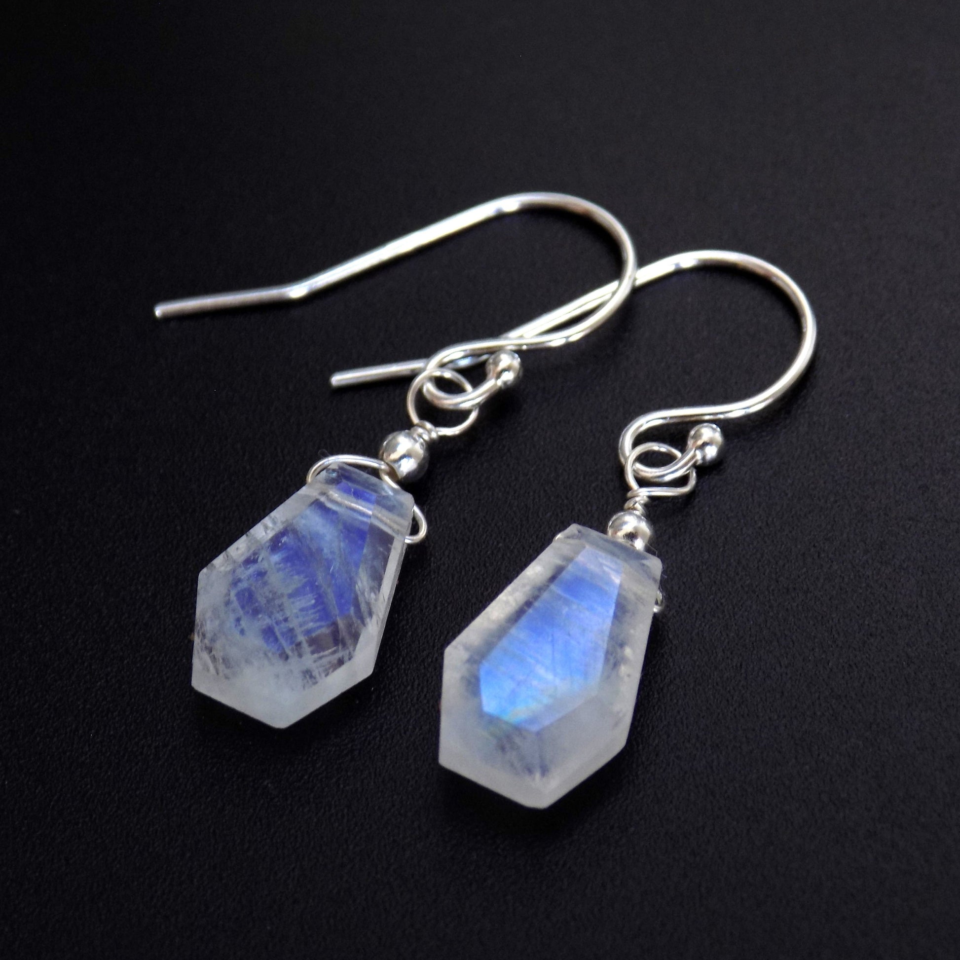 Close up of gothic moonstone earrings with silver ear hooks