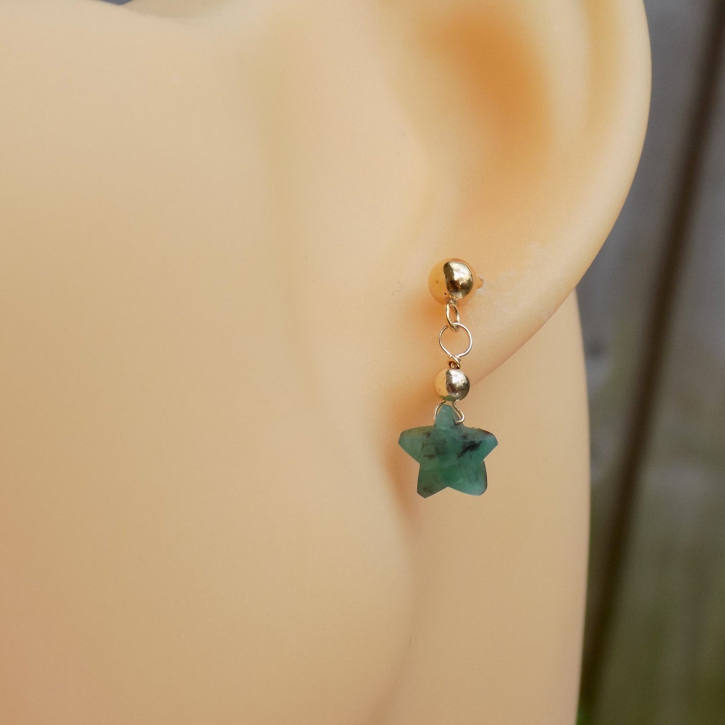 Real emerald stud earrings on model