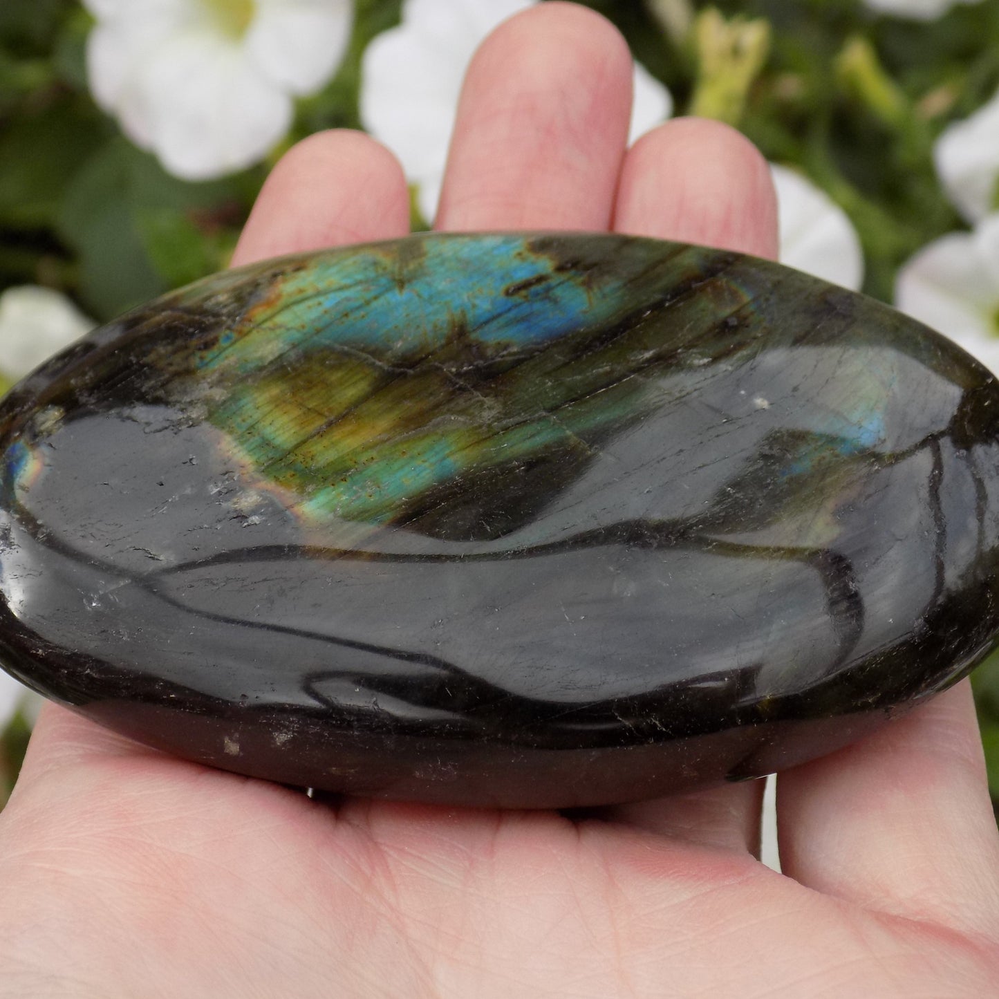 Smooth labradorite crystal on palm