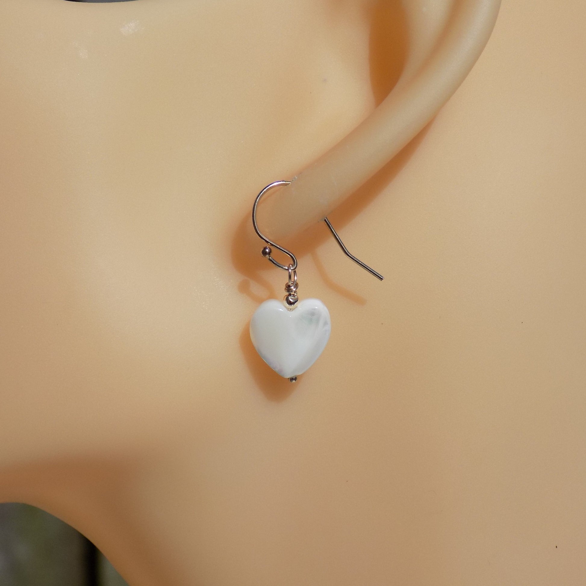 Mother of pearl heart shape earrings on model