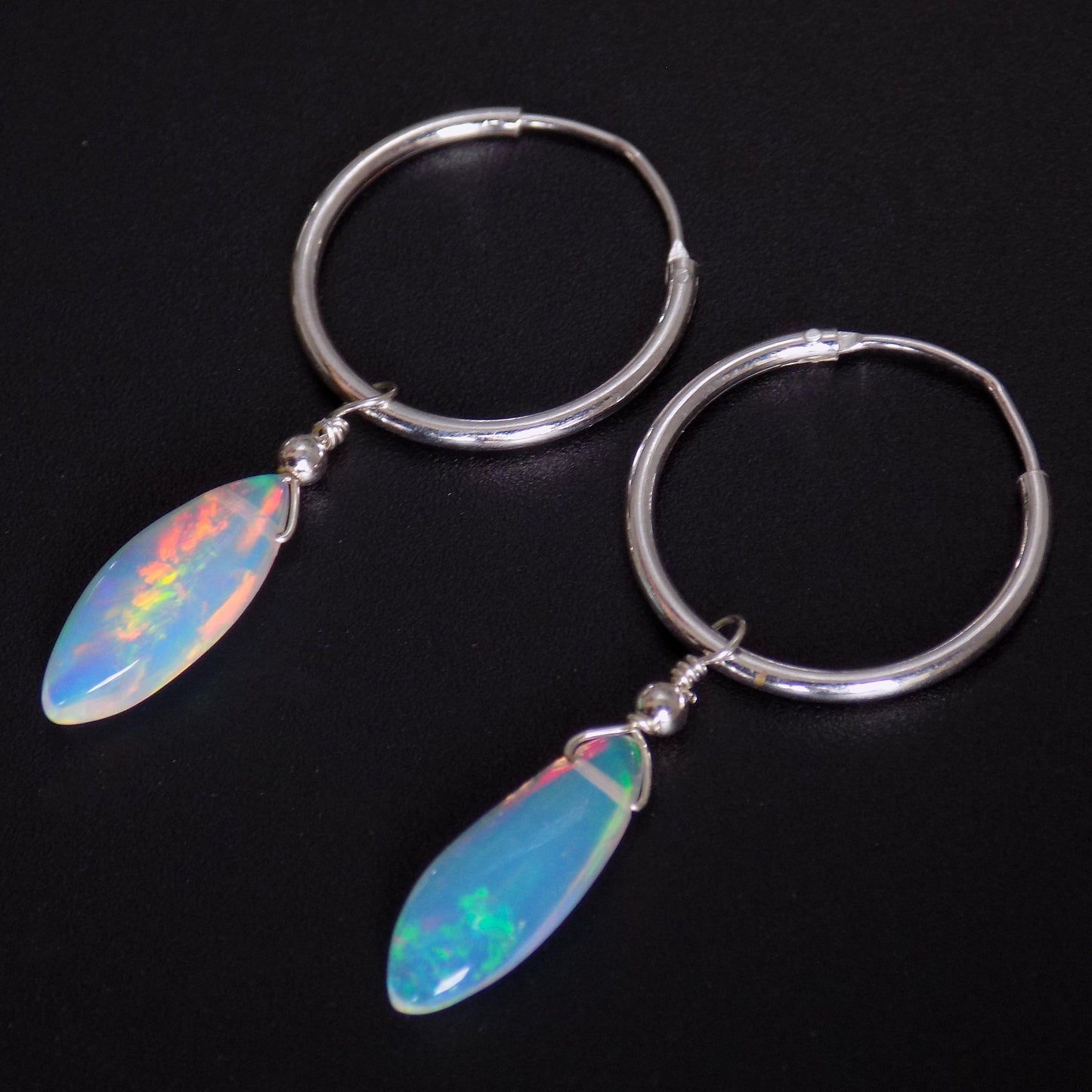 Close up of colourful opal hoop earrings