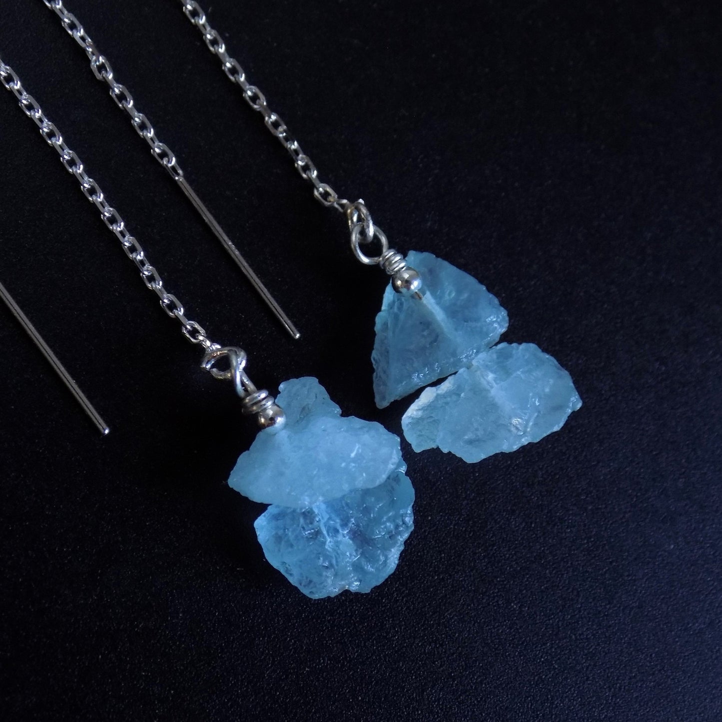 Aquamarine pull through earrings on black background